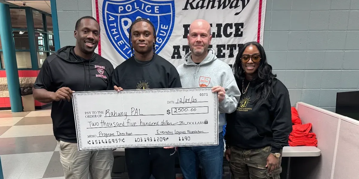 Jaylen McClain, Dr. Syreeta McClain, and the Police Athletic League's Dan Marchica and Darius Singletary with the foundation's donation check to Rahway PAL, under the league's banner.